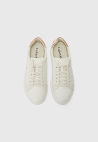 Sneakers bianchi con finitura in pelle liscia, dettagli rosa sul tallone, lacci piatti e design minimalista. Logo del marchio visibile all'interno.