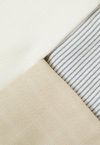 Three fabric swatches: textured off-white, beige with a grid pattern, and striped white with blue lines, showcasing varying patterns and colors.