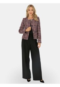 Marynarka tweedowa w odcieniach purpury, różu i bieli z teksturowanym wykończeniem, z okrągłym dekoltem i przednimi zapięciami na guziki. Szerokie czarne spodnie.