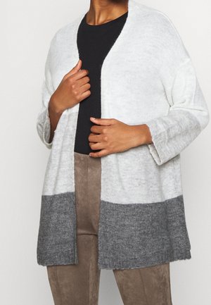 Cardigan leggero a maglia con parte superiore color crema, sezione inferiore grigia, apertura frontale e maniche a tre quarti. Tessuto morbido e vestibilità rilassata.
