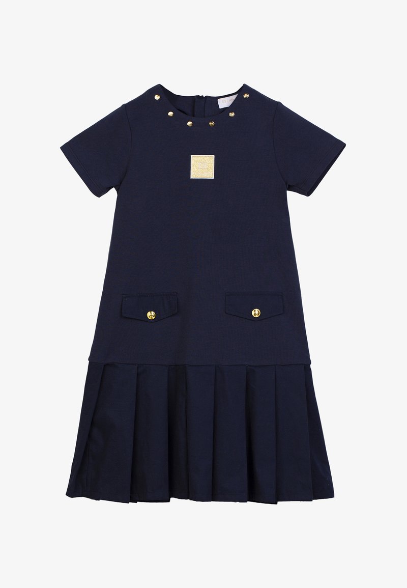 Abito navy a maniche corte con gonna plissettata, dettagli dorati e tasche frontali. Collo rotondo decorato con borchie dorate e dettaglio etichetta.