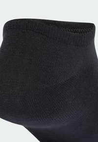 Čierna členková ponožka s rebrovanou textúrou, hladkým povrchom a zosilneným lemmom na vrchu. Ponožka je navrhnutá pre pohodlie a odolnosť.