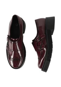 Scarpe in pelle laccata bordeaux con due fibbie, dettagli brogue, suola nera spessa e superficie liscia.