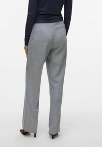 Pantaloni grigi a gamba larga realizzati in tessuto testurizzato, con un motivo sottile. La vista posteriore mostra una vita a media altezza e una vestibilità elegante.