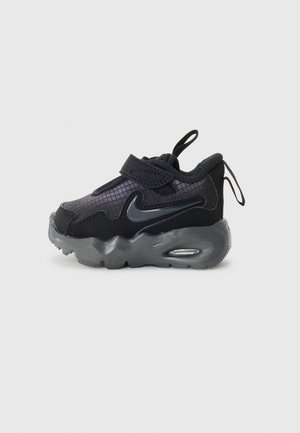 Črne teniske z teksturiranim zgornjim delom, vidno zračno podlogo, elastičnim pasom in zanko za poteg. Imajo gladko, ukrivljeno podplat za podporo.