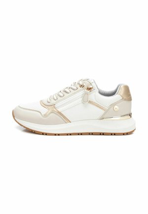 Zapatillas blancas y beige con acentos dorados, que cuentan con una parte superior de malla, un collar acolchado y una suela de goma con patrón. Detalle de cremallera en el lado.