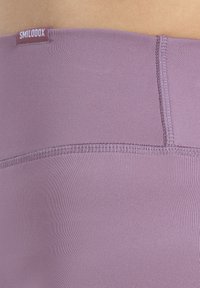 Legginsy sportowe w delikatnym odcieniu lawendy, wykonane z gładkiego elastycznego materiału i z płaskimi, wzmocnionymi szwami. Metka z logo przy pasie.