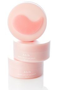 Patch oculaire rétinien PDRN dans un emballage rose, présentant une forme de patch gélifié texturé sur le dessus, empilés dans trois contenants cylindriques.