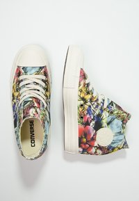 Hoge sneakers met een bloemenpatroon, voorzien van een crèmekleurige rubberen zool, witte veters en gouden metalen oogjes. Converse-logo op de zijpaneel.