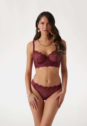 Bordeaux kanten bh en bijpassende slipset met bloemmotieven, gekartelde randen en satijnen accenten, aangevuld met delicate straps.