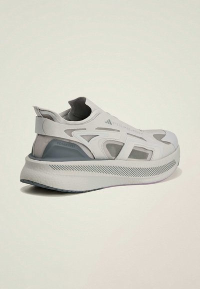 Baskets gris clair avec une tige en mesh et une silhouette incurvée. Dotées d'une semelle intermédiaire blanche épaisse et texturée, avec des accents gris. Sans lacets visibles.
