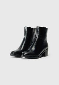 Stivali ankle in pelle nera con una finitura liscia, punta arrotondata e tacco a blocco. Presentano una cerniera laterale e una suola testurizzata.
