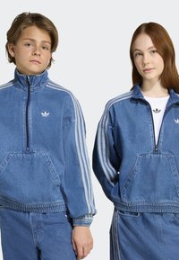 Džinsiniai zip-up švarkai su baltais trimis dryžiais, kengūros kišenėmis ir elastingomis rankovėmis, su mažuoju prekės ženklu ant krūtinės.