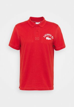 Rode polo shirt van zacht katoen, met een klassieke kraag, een twee-knopen sluiting en een wit geborduurd logo op de borst.