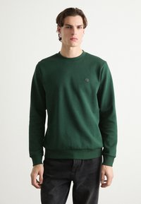 Felpa verde in tessuto misto cotone, collo a giro, polsini e orlo a costine, presenta un piccolo logo nero sul petto, design attillato.