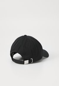 Svart bomull baseball cap med buet skygge, justerbar stropp med sølvmetallspenne, og ventilasjonshull bak.