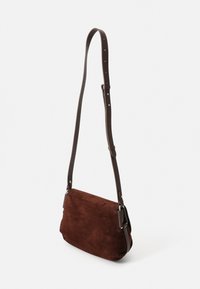 Borsa a spalla in suede marrone con design piatto, tracolla in pelle marrone regolabile, hardware in argento e dettagli di cucitura minimalisti.