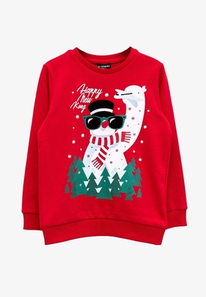 Felpa rossa con un pupazzo di neve che indossa occhiali da sole, un cappello e una sciarpa a righe, circondato da pini verdi e fiocchi di neve che cadono.