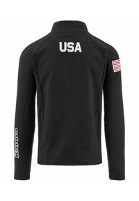 Giacca sportiva nera con maniche lunghe, con "USA" in bianco sul retro, una piccola topa americana sulla manica destra e il logo Kappa sulla manica sinistra.