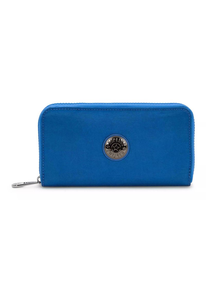 Blauwe ritstas met een gladde textuur, uitgerust met een ronde metalen logo en contrasterende stiksels langs de rand.