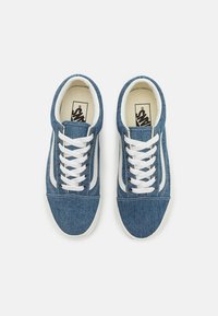 Tenisi din denim albastru cu sireturi albe și tălpi din cauciuc. Prezintă o suprafață din țesătură texturată și un design cu dungi contrastante pe laterale.