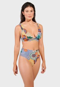 Flerfärgad bikini set som har en djup V-ringad topp och högmidjade underdelar, tillverkad av ett mjukt tyg med blommiga och geometriska mönster.