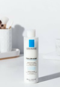 White plastic bottle of La Roche-Posay Toleriane Dermo-Cleanser. Blue square logo, black and blue text, 200ml size. Simple, sleek design.