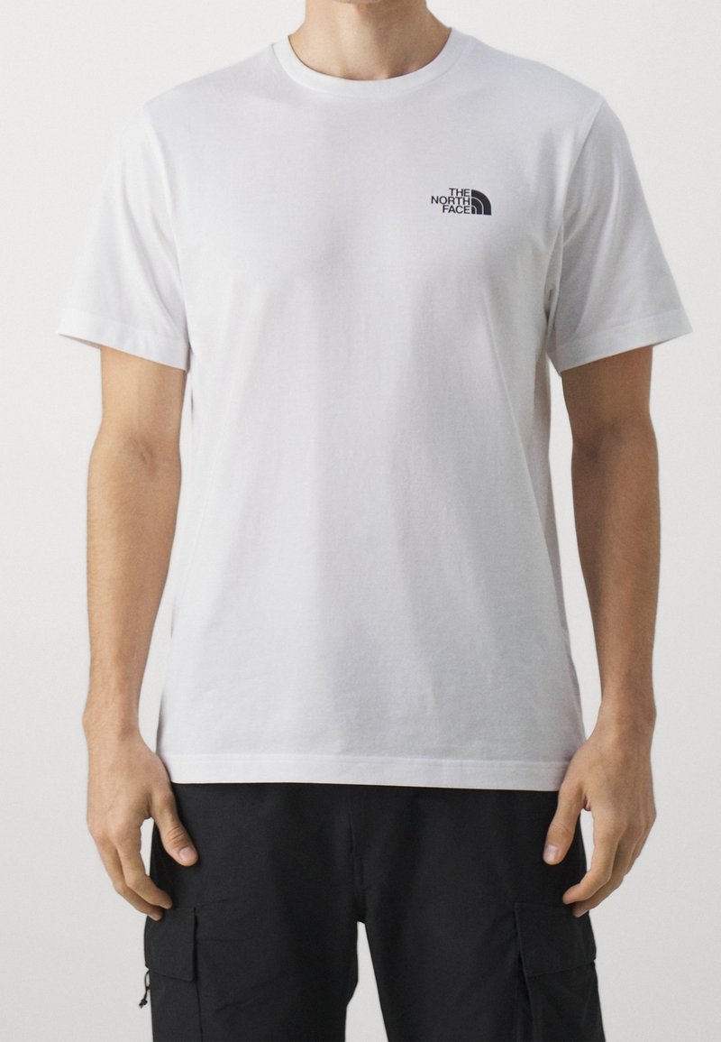 Camiseta de algodón blanca con un logo negro de The North Face en el lado izquierdo del pecho, con cuello redondo clásico y mangas cortas.