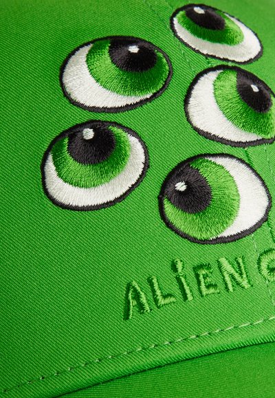 Φωτεινό πράσινο ύφασμα με πέντε κεντημένα μάτια σε πράσινο και μαύρο χρώμα και μερικό κείμενο "ALIENS" κεντημένο κάτω από τα μάτια.
