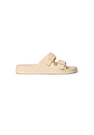 Beige slip-sandal med to justerbare stropper med spænder og tekstureret sål, designet til afslappet brug, vist fra siden på hvid baggrund.
