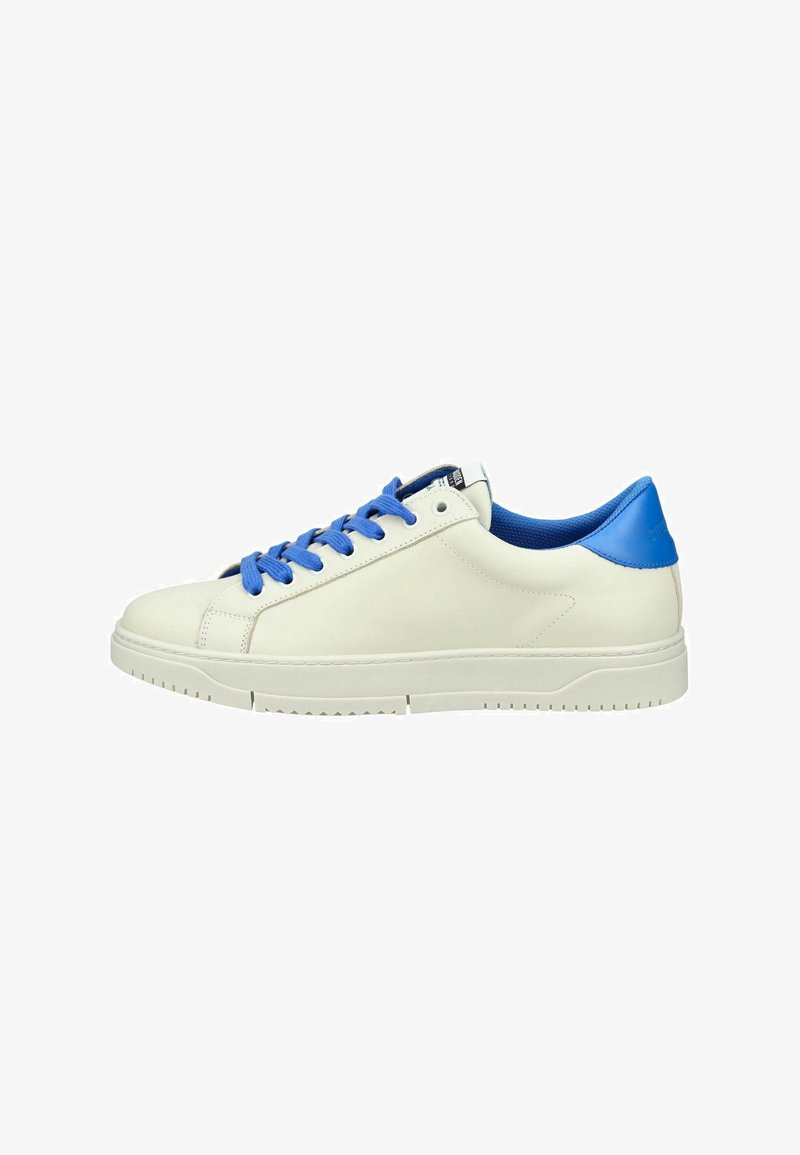 Basket blanc à tige basse avec lacets bleus et languette de talon bleue, semelle plate et détails de couture minimaux sur un fond blanc uni.
