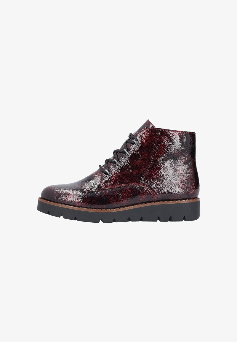 Stivaletti a metà altezza con finitura in pelle patinata bordeaux screpolata, lacci neri e suola in gomma testurizzata. Accentuati da un dettaglio circolare con logo.
