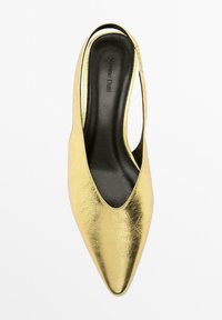 Chaussure slingback métallique dorée avec un bout pointu et un intérieur noir. Texture lisse avec un léger effet froissé à la surface.