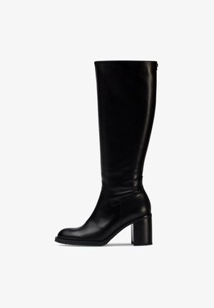 Bota de cuero negro hasta la rodilla con punta redonda, tacón grueso y textura suave. Presenta un detalle de costura en la parte delantera y trasera.