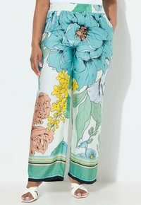 Pantalons larges avec un imprimé floral en teal, jaune et marron. Dotés d'une taille élastique et d'un ourlet rayé aux couleurs variées.