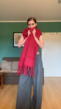 Punane villane sall, millel on narmad, koos hallide laia lõikega pükstega. Taustal on rohelise seina ja diivani kõrgus.