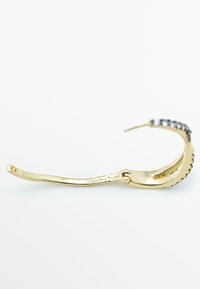 Occhiali da sole in metallo color oro con montatura curva, dettagli testurizzati e nome del marchio inciso. Presentano una finitura lucida e dettagli di design intricati.