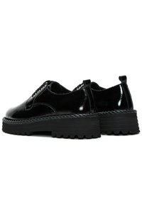 Chaussures en cuir verni noir avec une semelle en caoutchouc épaisse, présentant des lacets et un accent en corde le long du bord de la semelle. Bout arrondi et tirette à l'arrière.