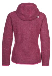 Fleece hoodie, rosa heathertextur, med en figurnära design. Har en huva, kontrasterande sömmar och en liten logotyp på bakre axel.