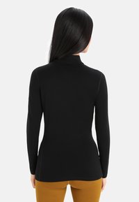 Sort langærmet turtleneck-top med en tætsiddende design og glat tekstur, der har en høj krave og sømløst syning.