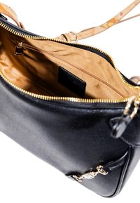 Borsa a tracolla in pelle nera con zip dorata, fodera interna beige, tasca interna con zip e tracolla beige a fantasia visibile.