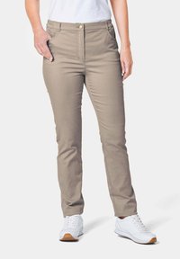 Beige broek met een knoopsluiting aan de voorkant, slim fit, en zijzakken, gecombineerd met witte sportschoenen en een wit topje.