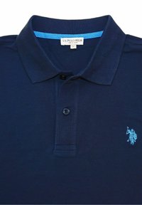 Granatowa koszulka polo z teksturowanej tkaniny, z niebieskim akcentem na kołnierzyku i małym haftowanym logo na piersi.