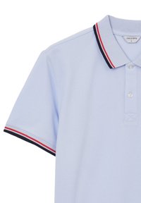 Polo shirt azzurro chiaro con maniche corte, due bottoni bianchi e rifiniture a strisce blu navy, rosse e bianche su colletto e maniche.