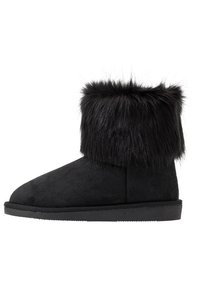 Stivaletto nero in suede, caratterizzato da un morbido risvolto in pelliccia sintetica, punta arrotondata e suola piatta in gomma. Design semplice senza hardware visibile.