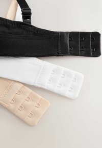 Kolme rintaliivinhihnaa mustana, valkoisena ja beigenä, jokaisessa on kolmirivinen koukku- ja silmukkakiinnitys vaalealla taustalla.