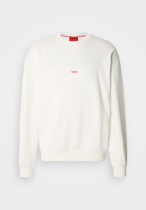 Biela mikina vyrobená z mäkkého materiálu, s okrúhlym výstrihom, dlhými rukávmi a malým červeným logom "HUGO" na hrudi.
