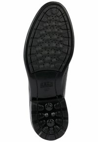 Semelle de chaussure en caoutchouc noir présentant une surface texturée avec des motifs circulaires et des trous de drainage, marquée du logo "GEOX ULTRA COMFORT".