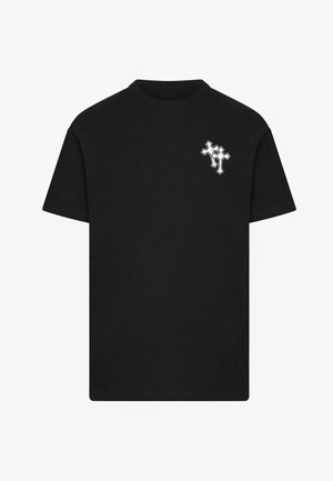 Mustvalge puuvillane T-särk, millel on väike valge tikand vasakul rinnaku kohal. Lühikesed varrukad ja ümmargune kaelus.