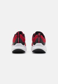 Zapatillas deportivas rojas y negras con parte superior de malla, suela blanca acolchada y suela exterior de goma texturizada. Presenta una lengüeta en el talón.